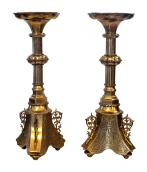 A pair of Gothic Revival brass candlesticks